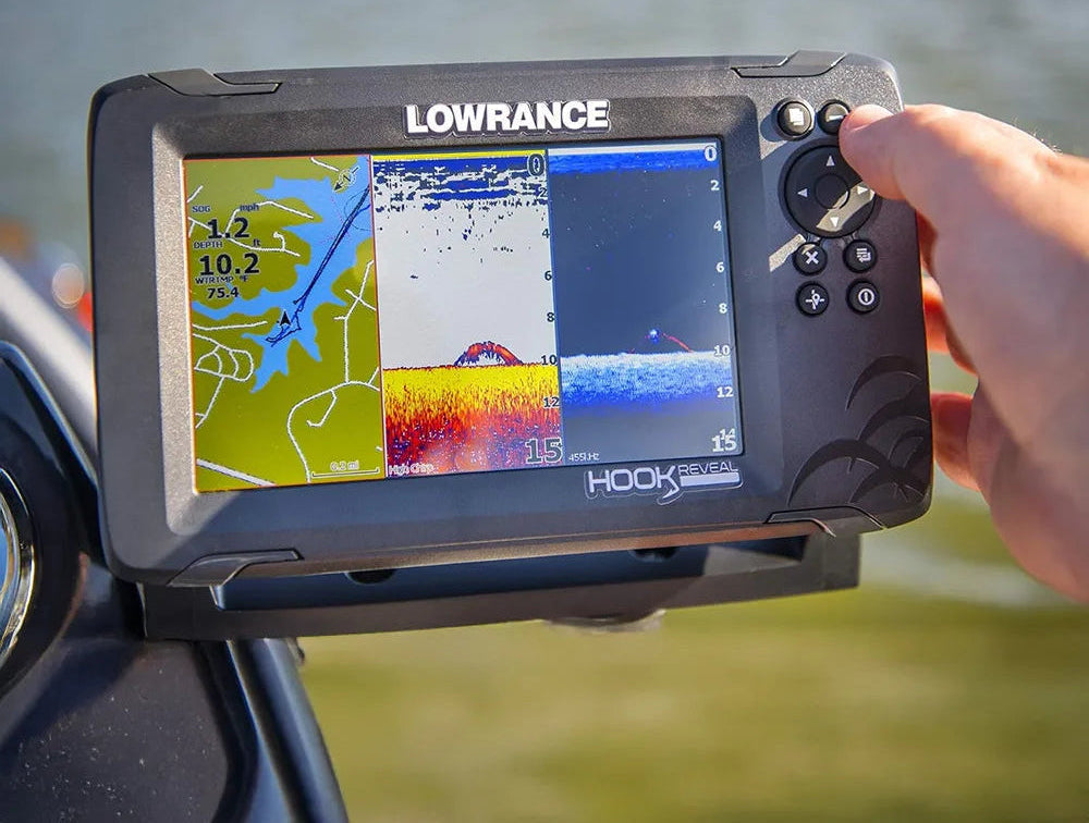 Lowrance fishing display held by a person with water in the background